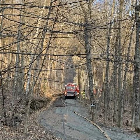 long hose on the ground attached to fire truck in the woods long hose on the ground attached to fire truck in the woods